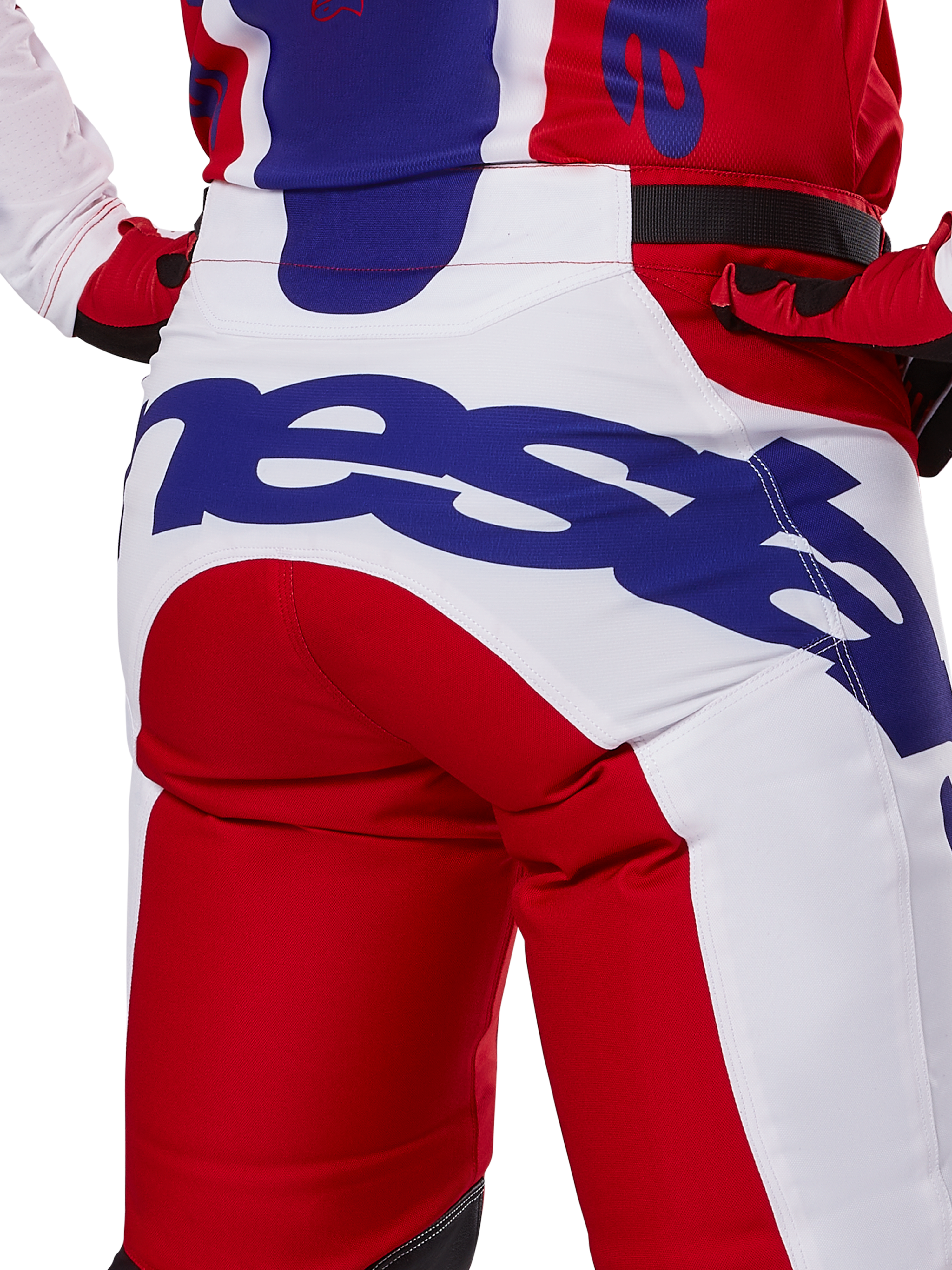 Alpinestars 2025 Racer Veil Pants, pantalon de motocross, rouge vif et blanc avec logo bleu, vue arrière détaillée de l'assise présentant un grand logo Alpinestars, porté dans le cadre d'une tenue de course tout-terrain coordonnée