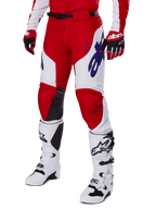 Alpinestars 2025 Racer Veil Pants, pantalon de motocross, rouge éclatant et blanc, avec logos Alpinestars bleus et panneaux intérieurs aux genoux en cuir noir, porté avec des gants rouges et des bottes de motocross blanches assorties, tenue coordonnée pour le tout-terrain