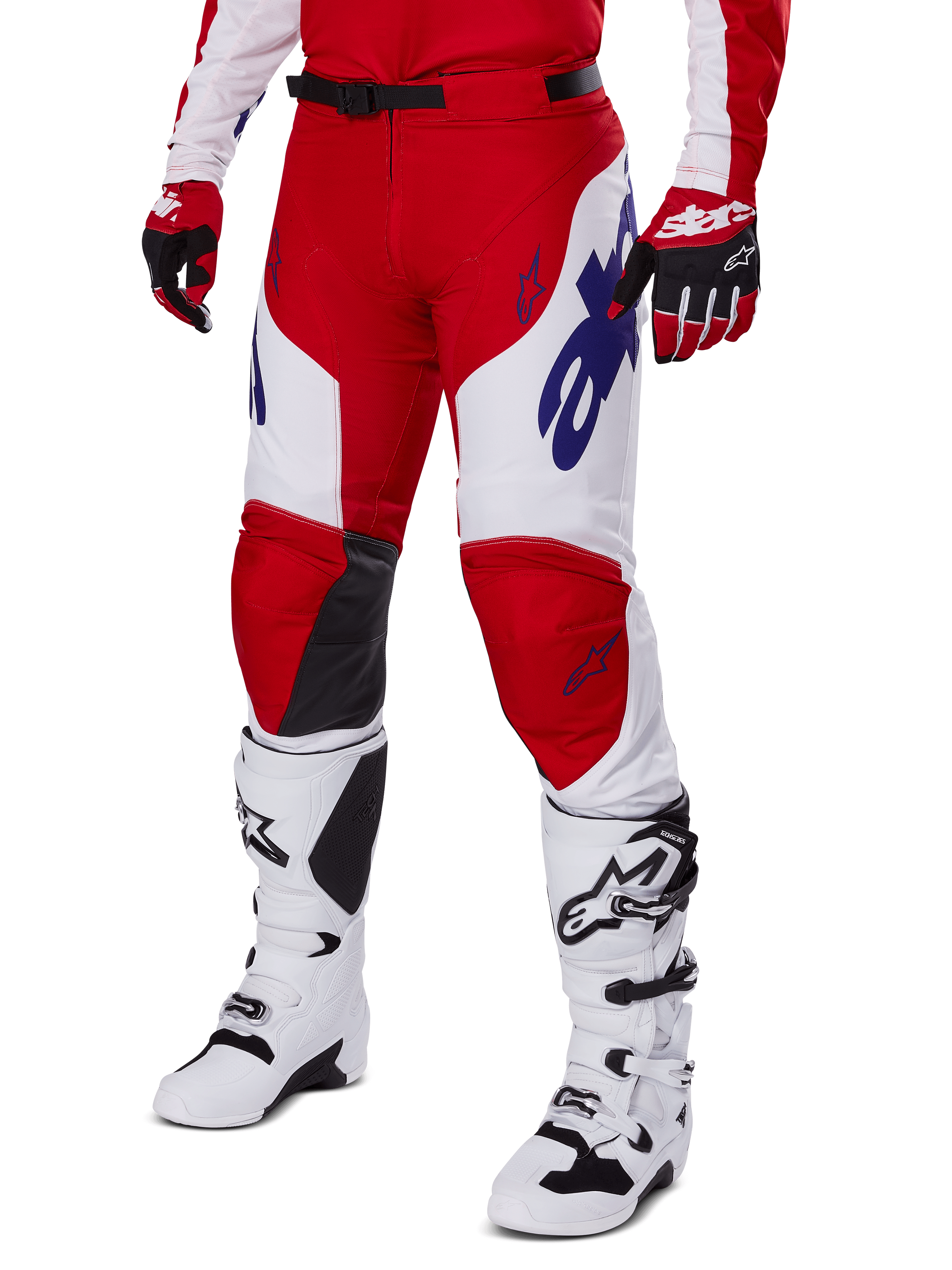 Alpinestars 2025 Racer Veil Pants, pantalon de motocross, rouge éclatant et blanc, avec logos Alpinestars bleus et panneaux intérieurs aux genoux en cuir noir, porté avec des gants rouges et des bottes de motocross blanches assorties, tenue coordonnée pour le tout-terrain