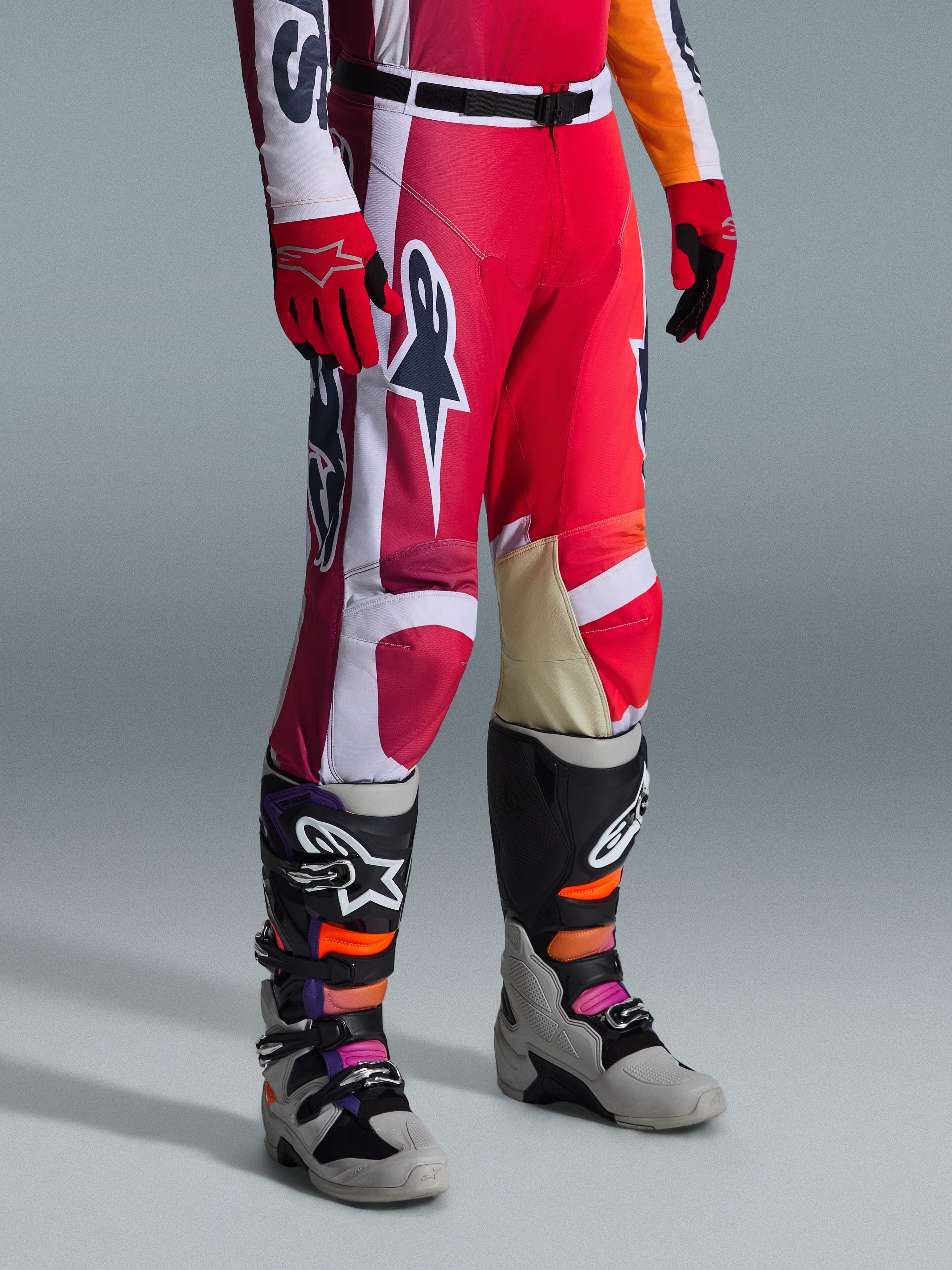 Alpinestars 2026 Racer Portl Pants, Motocross Pants, Red Light Gray and Dark Gray, worn with matching red gloves and multi-colored motocross boots, featuring bold Alpinestars logos and reinforced panels for off-road racing.