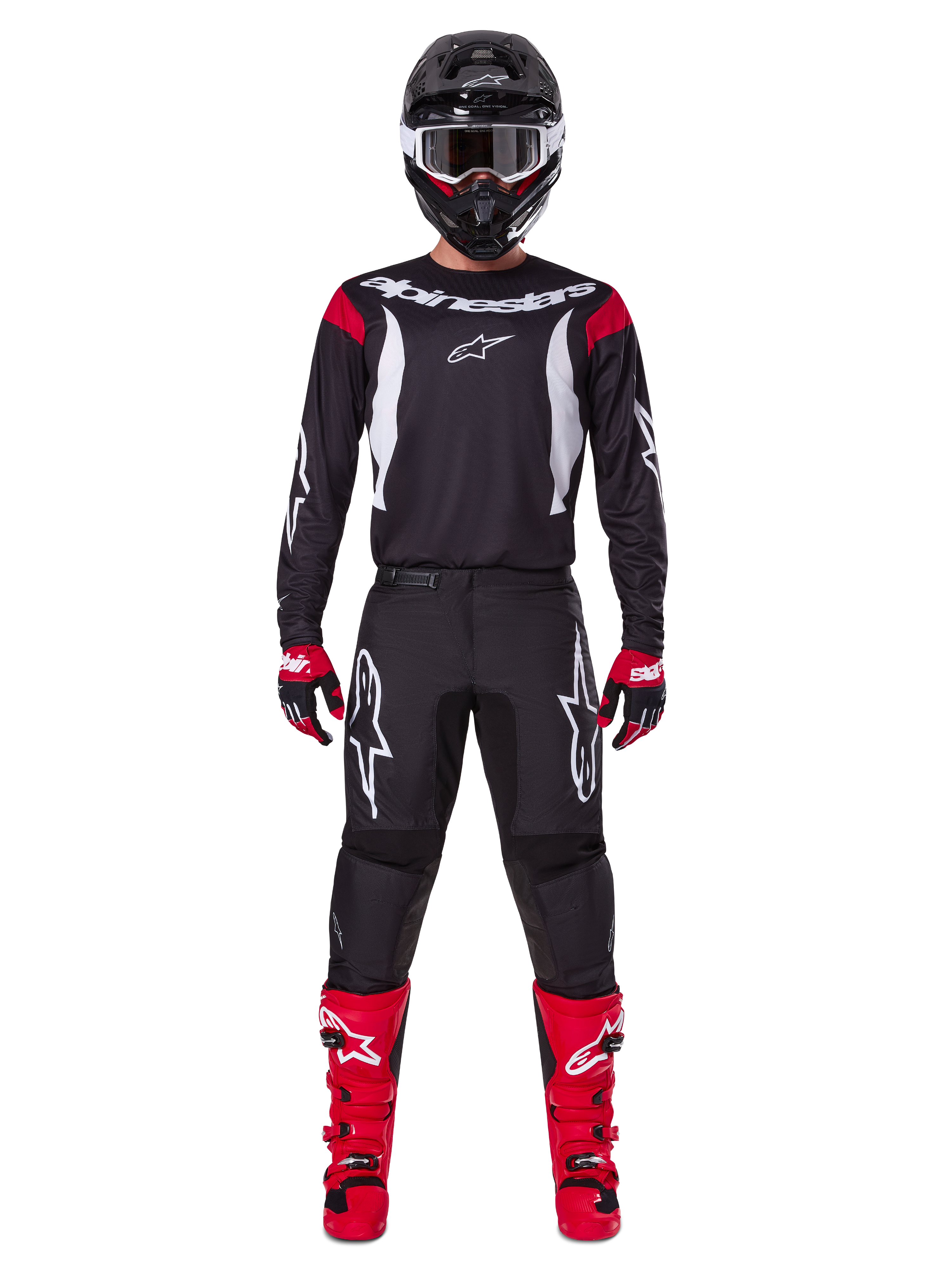 Ensemble d'équipement Alpinestars 2025 Fluid Haul, pilote de motocross en tenue de course complète, maillot noir avec accents rouges aux épaules et logos blancs, pantalon noir avec logo étoile blanc, bottes rouge vif, gants rouges et noirs, casque noir avec lunettes blanches, look de performance tout-terrain coordonné