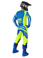 Motocross rider from behind wearing Alpinestars 2025 Fluid Haul Pants and matching jersey in Yellow Fluo and Blue, coordinated with blue boots and a black Alpinestars helmet, professional off-road racing gear
