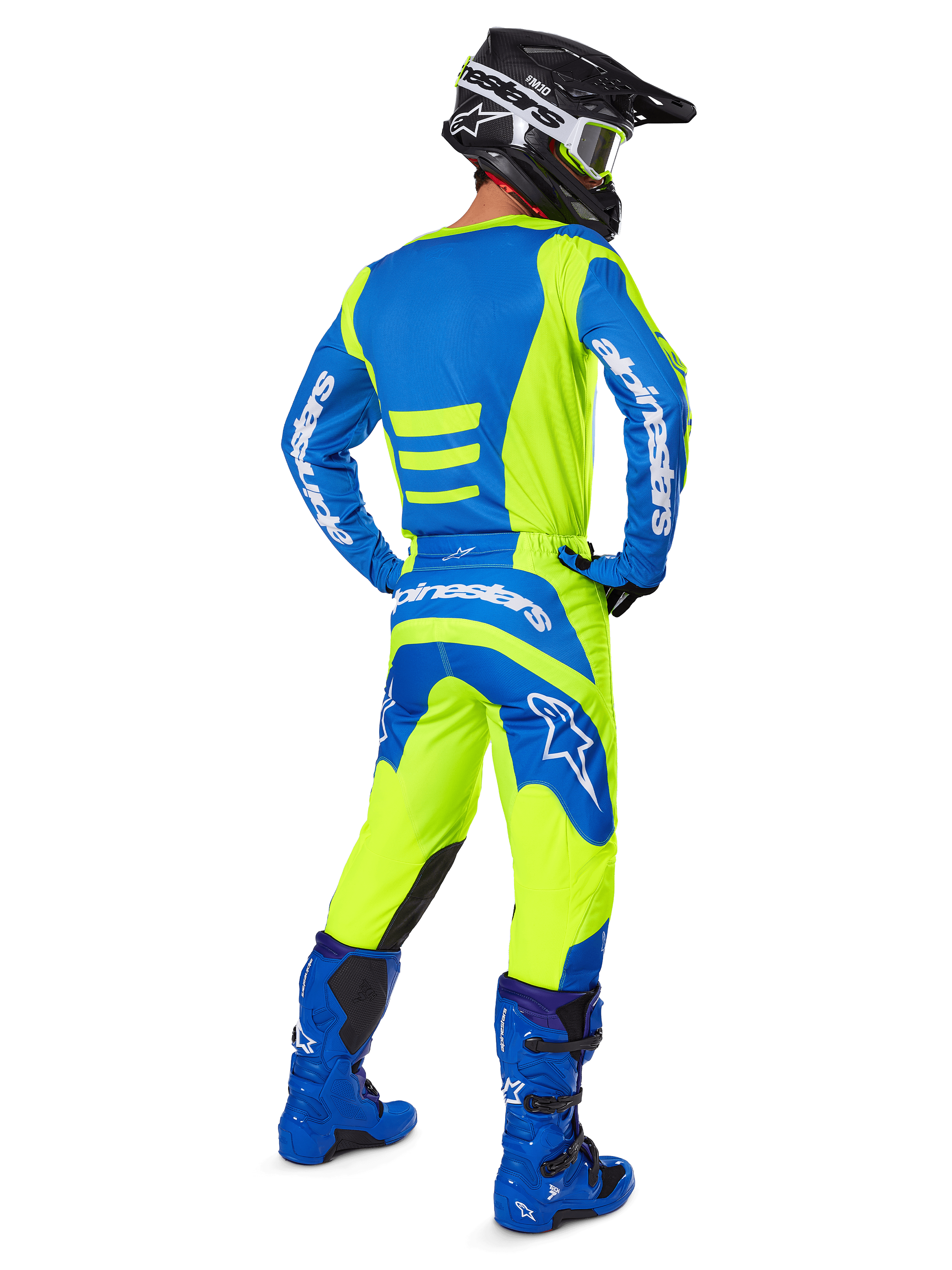 Motocross rider from behind wearing Alpinestars 2025 Fluid Haul Pants and matching jersey in Yellow Fluo and Blue, coordinated with blue boots and a black Alpinestars helmet, professional off-road racing gear