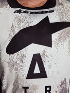 Alpinestars 2026 Racer Lahnd Jersey, close-up of chest area, Sand Camo pattern with large black star logo and Alpinestars wordmark, breathable performance polyfabric for off-road riding