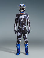 Alpinestars 2026 Racer Lahnd Gear Set, Motocross Outfit, Black and White with Iron Camo abstract pattern, paired with blue and white helmet and bright blue boots, complete racing kit for off-road performance