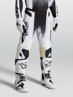 Alpinestars Techstar Swan Motocross Pants, White and Black race-fit gear on-model with matching boots, high-performance stretch ripstop design.