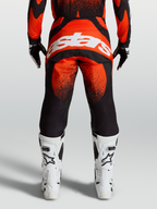 Alpinestars Techstar Swan Pants, Red and Black motocross gear, on-model rear view with white Alpinestars logo and white racing boots.
