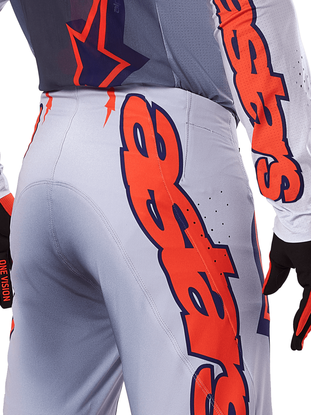 Ensemble maillot et pantalon Alpinestars Supertech Lipan 2025, tenue de motocross, gris et orange fluo, gros plan sur le côté et l'arrière montrant le grand logo Alpinestars orange, tissu ripstop haute performance avec ventilations perforées