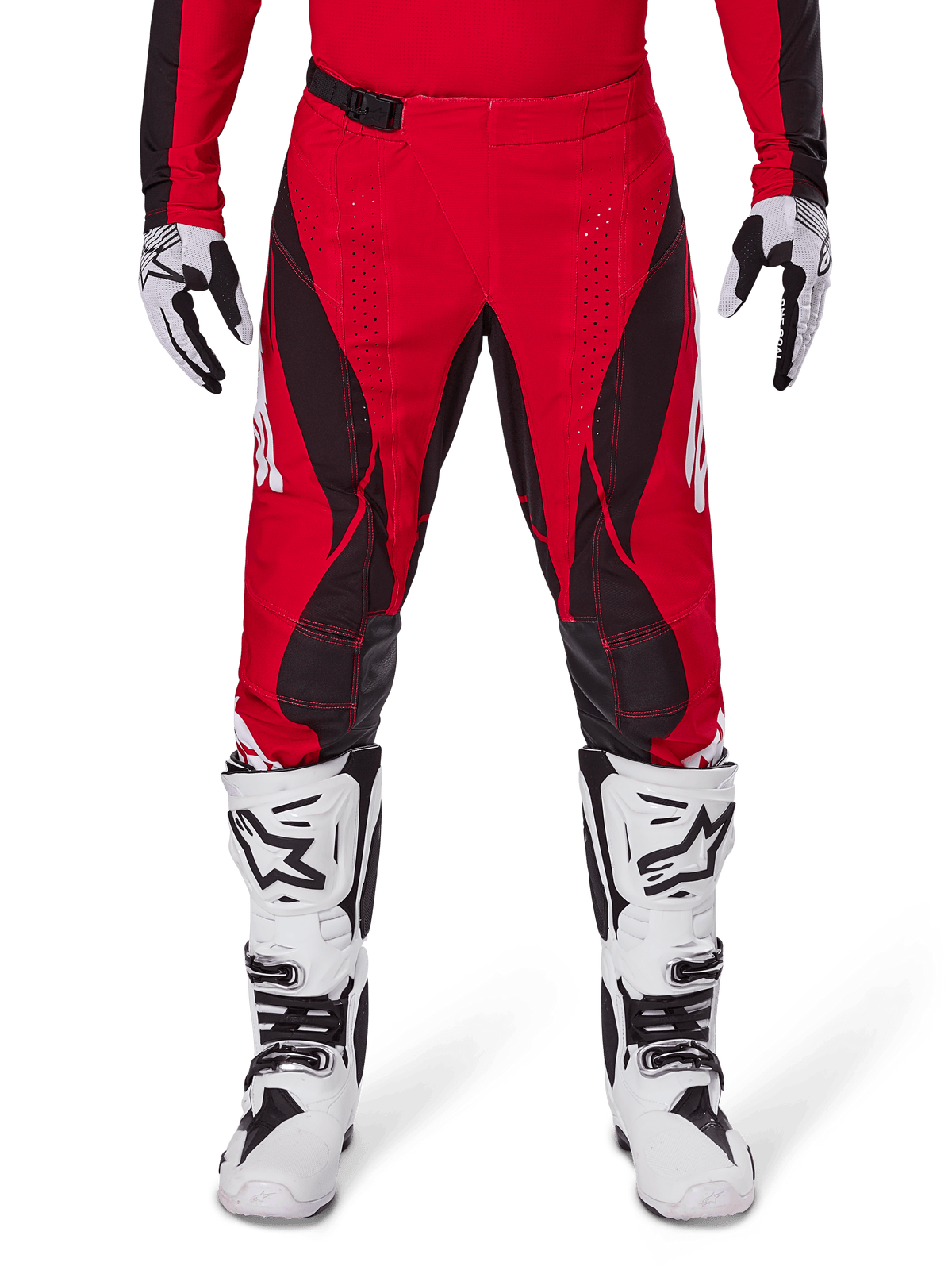 Pantalon Alpinestars Techstar Dreem 2025, pantalon de motocross rouge vif et noir avec motifs angulaires et perforations laser, porté avec des bottes de motocross blanches et des gants assortis pour la course tout-terrain