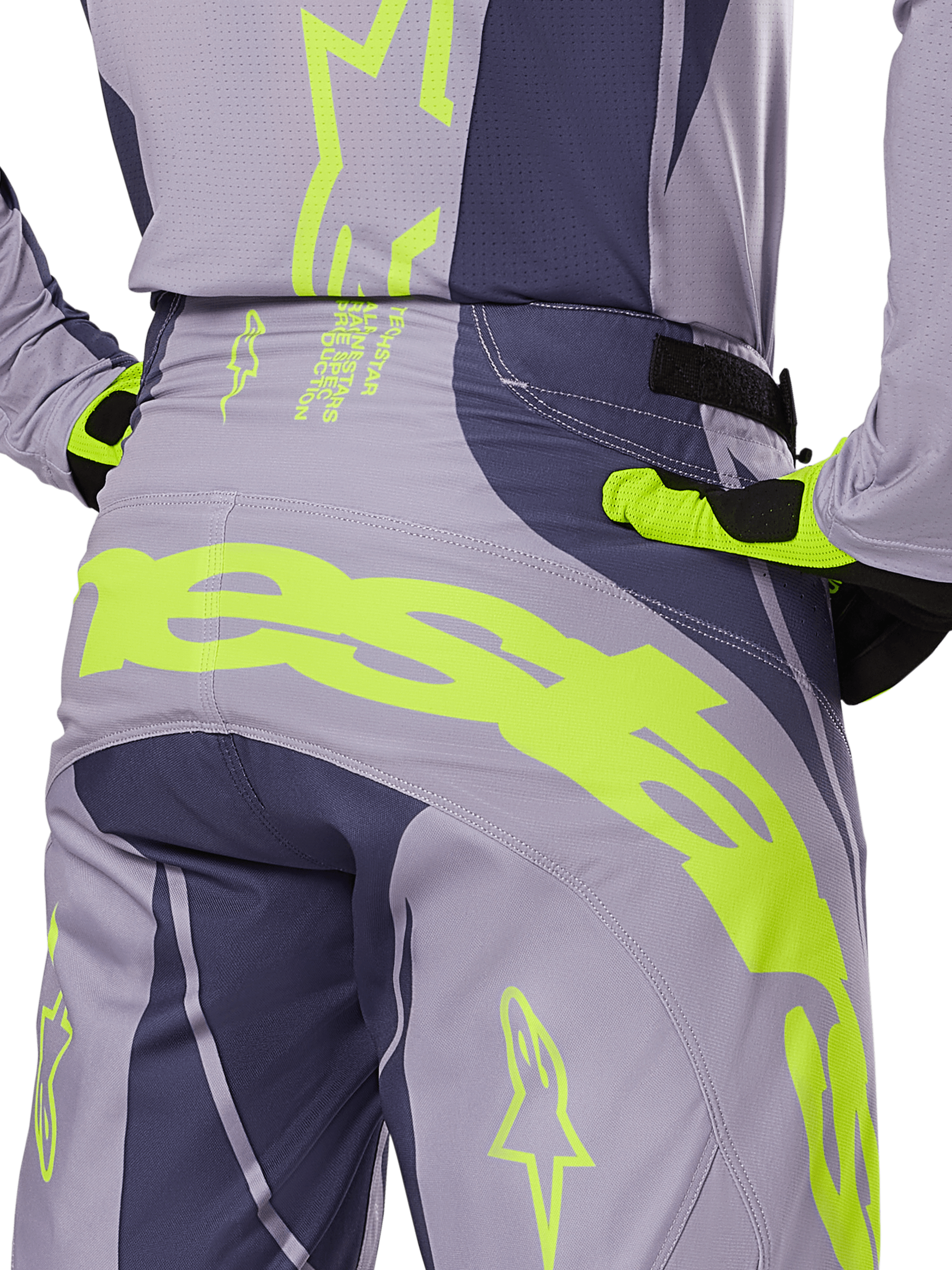 Alpinestars 2025 Techstar Dreem Pants, pantalon de motocross, gris et gris foncé avec accents jaune fluo, vue arrière montrant le marquage Alpinestars imposant sur l'empiècement, porté avec le maillot et les gants assortis, conçu pour la course tout-terrain