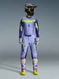 Ensemble d'équipement Alpinestars 2026 Supertech Scenz, tenue de course de motocross, violet clair et jaune-vert néon, équipement de protection complet comprenant un casque noir avec des accents violets, un maillot avec un marquage jaune néon audacieux, un pantalon assorti avec des graphismes d'étoiles et des bottes coordonnées avec des touches roses.