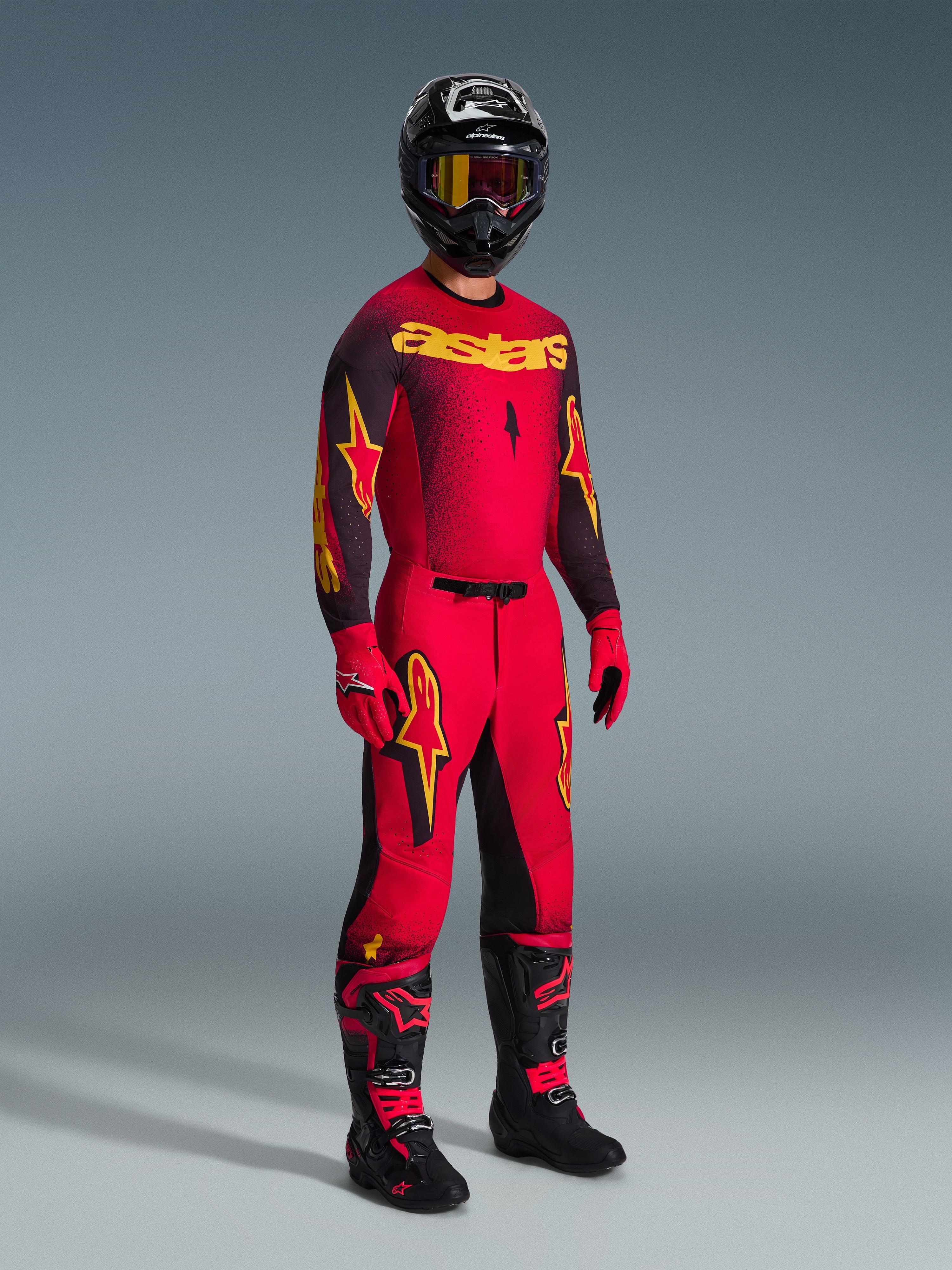 Alpinestars 2026 Supertech Scenz Pants, Motocross Pants, Red Black and Yellow, worn by a rider in a complete racing gear set with matching jersey and boots, featuring bold yellow and black star logos and an athletic fit.