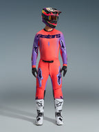 Alpinestars 2026 Supertech Scenz Pants, Motocross Pants, Hot Coral and Purple, worn as a complete gear set with matching jersey and helmet, white and black boots, featuring purple logos and athletic racing fit.