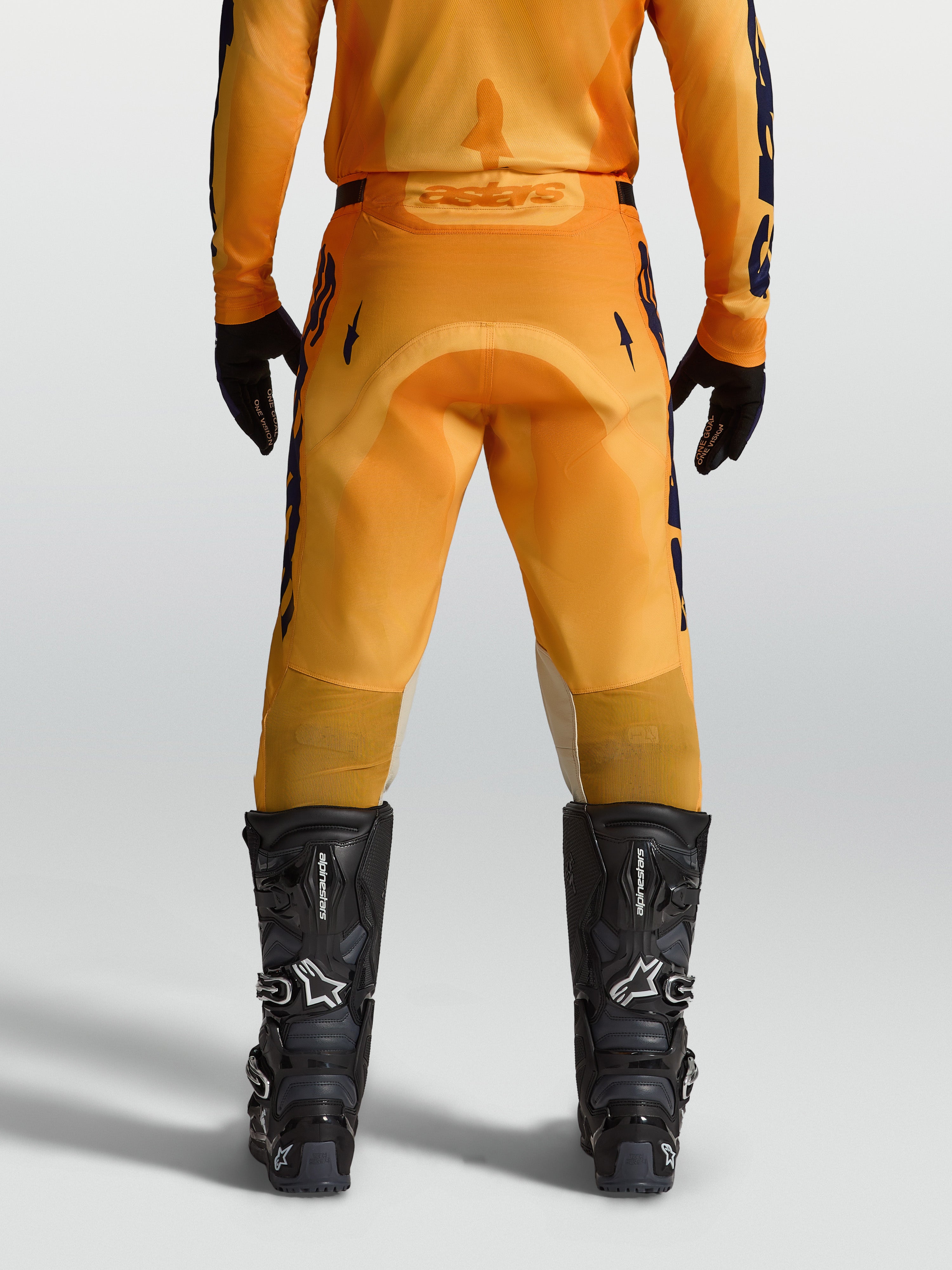 Alpinestars Racer Amber, pantalon de motocross pour homme, orange et bleu foncé, vue de dos avec assise renforcée et inserts extensibles, conçu pour le pilotage tout-terrain