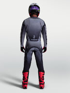Pantalon Racer Amber Alpinestars, ensemble de motocross pour homme, gris et lilas clair, vue de dos avec bottes de moto rouges, équipement de protection tout-terrain