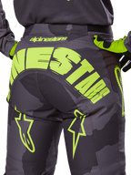 Alpinestars 2025 Racer Hollow Pants, Motocross Pants, Dark Camo and Yellow Fluo, featuring a large yellow Alpinestars logo across the rear, tactical camo pattern with bright yellow accents, and durable construction for off-road racing.