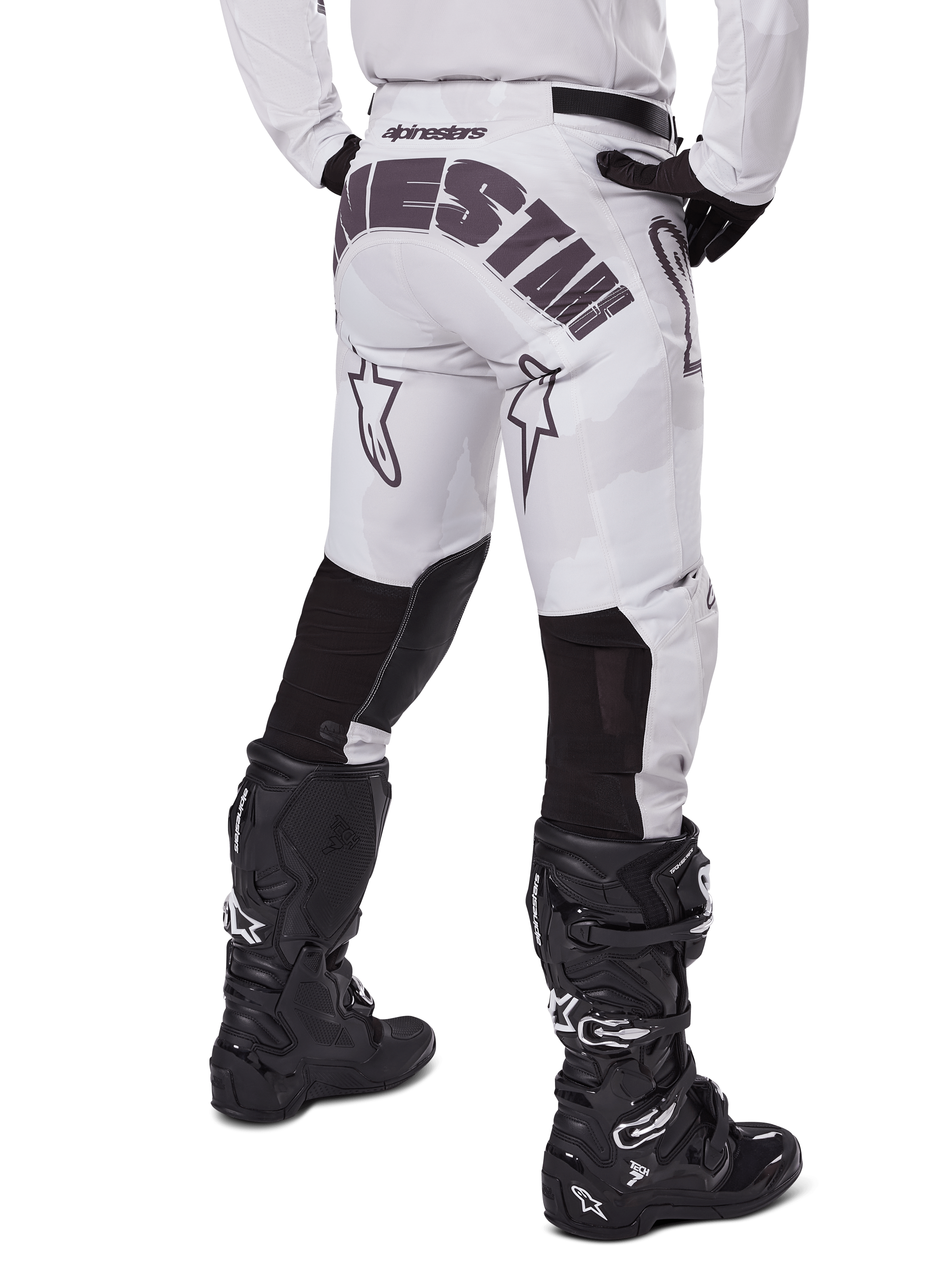 Alpinestars 2025 Racer Hollow Pants, pantalon de motocross, brun camouflage clair, vue arrière du pilote montrant un logo imposant sur l'assise et des empiècements extensibles noirs sur le bas des jambes, associé à des bottes Tech 7 noires