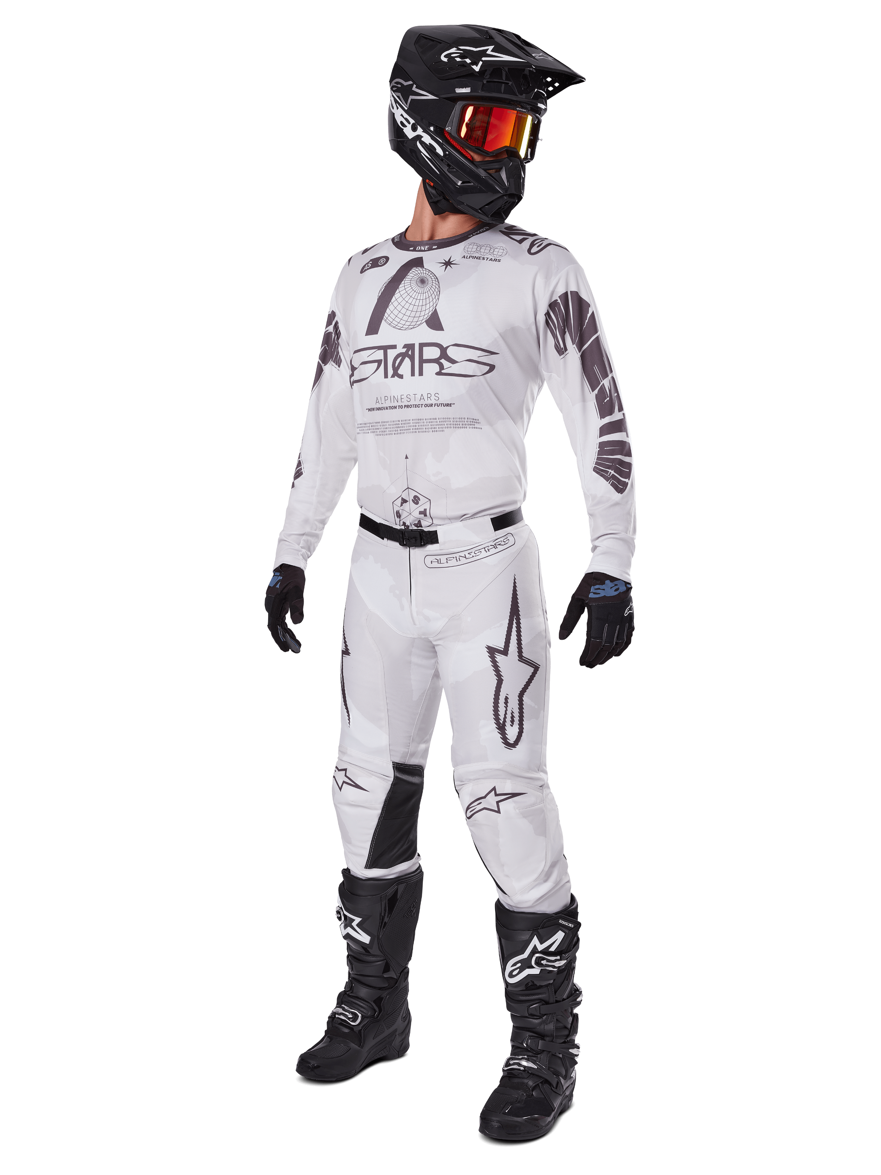 Alpinestars 2025 Racer Hollow Pants, pantalon de motocross, Brun Camo Clair, présenté dans un kit de course complet avec maillot blanc, casque noir et bottes noires, doté de panneaux de genoux noirs renforcés et d'un motif camouflage subtil.