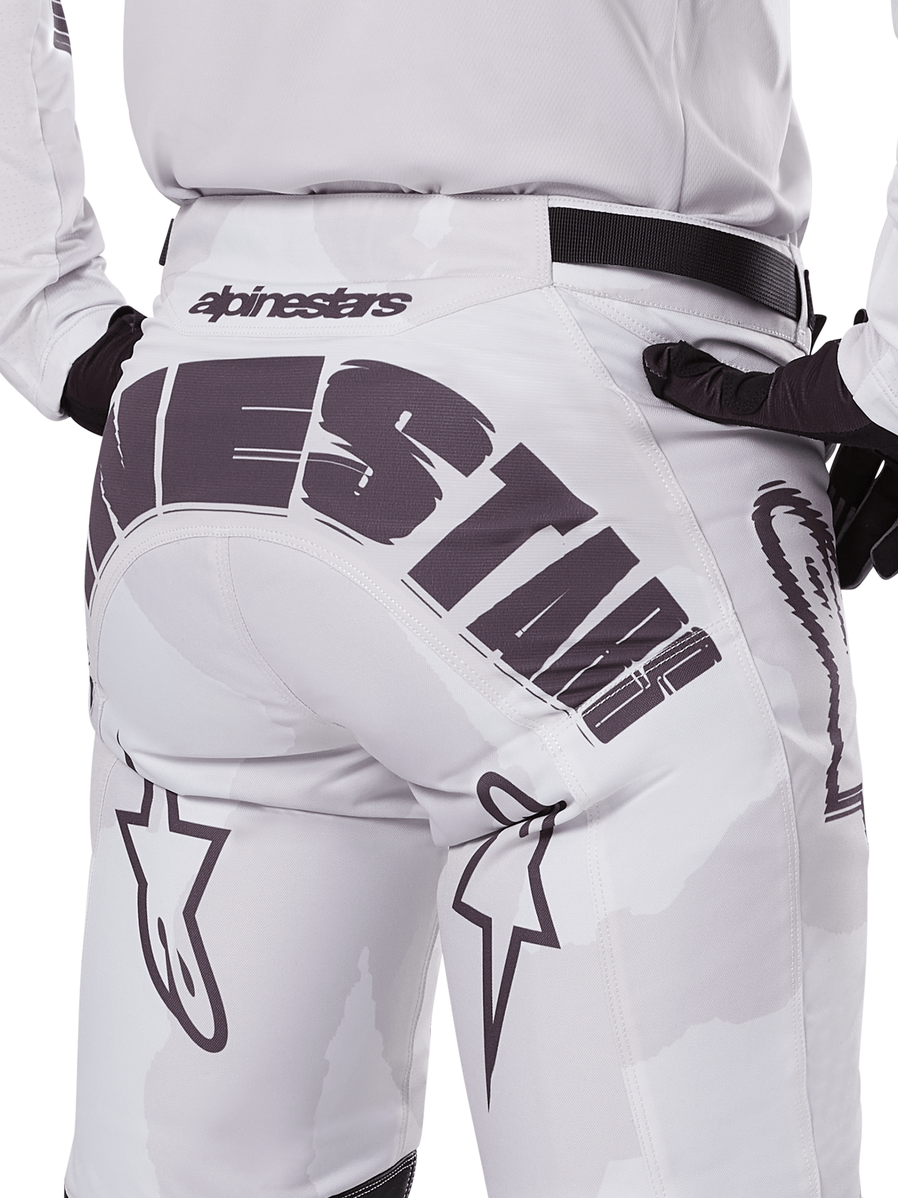 Alpinestars 2025 Racer Hollow Pants, pantalon de motocross, Light Camo Brown, vue arrière rapprochée présentant un grand marquage Alpinestars sur l'assise, des logos d'étoiles sur les jambes et une sangle de réglage noire à la taille, conçu pour la course tout-terrain