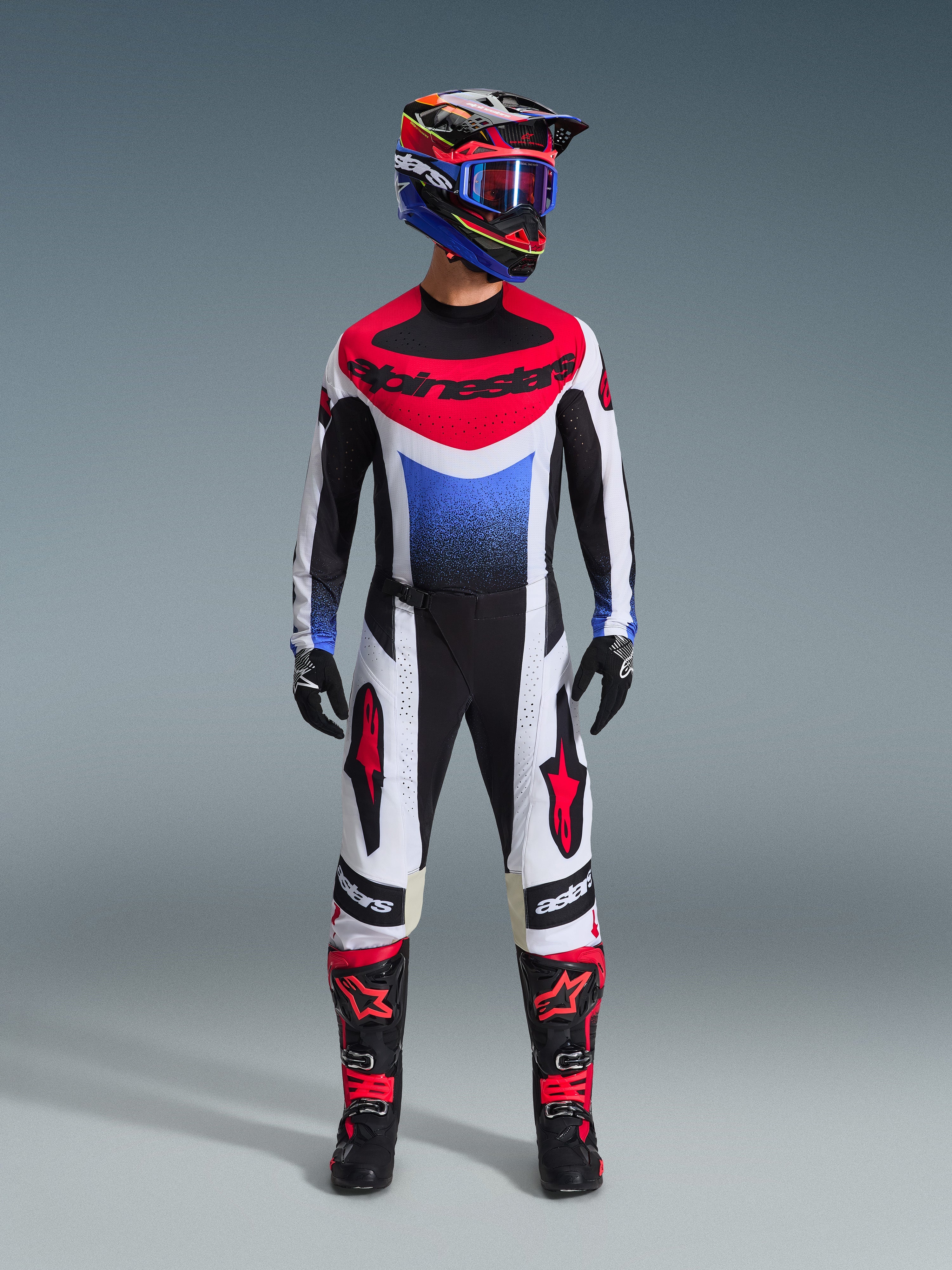 Ensemble d'équipement Alpinestars 2026 Techstar Knif, tenue de motocross complète, maillot rouge, blanc et bleu avec logo Alpinestars, pantalon assorti blanc et noir avec détails rouges, casque de course coloré avec lunettes bleues, bottes noires avec accents rouges, kit de course MX complet