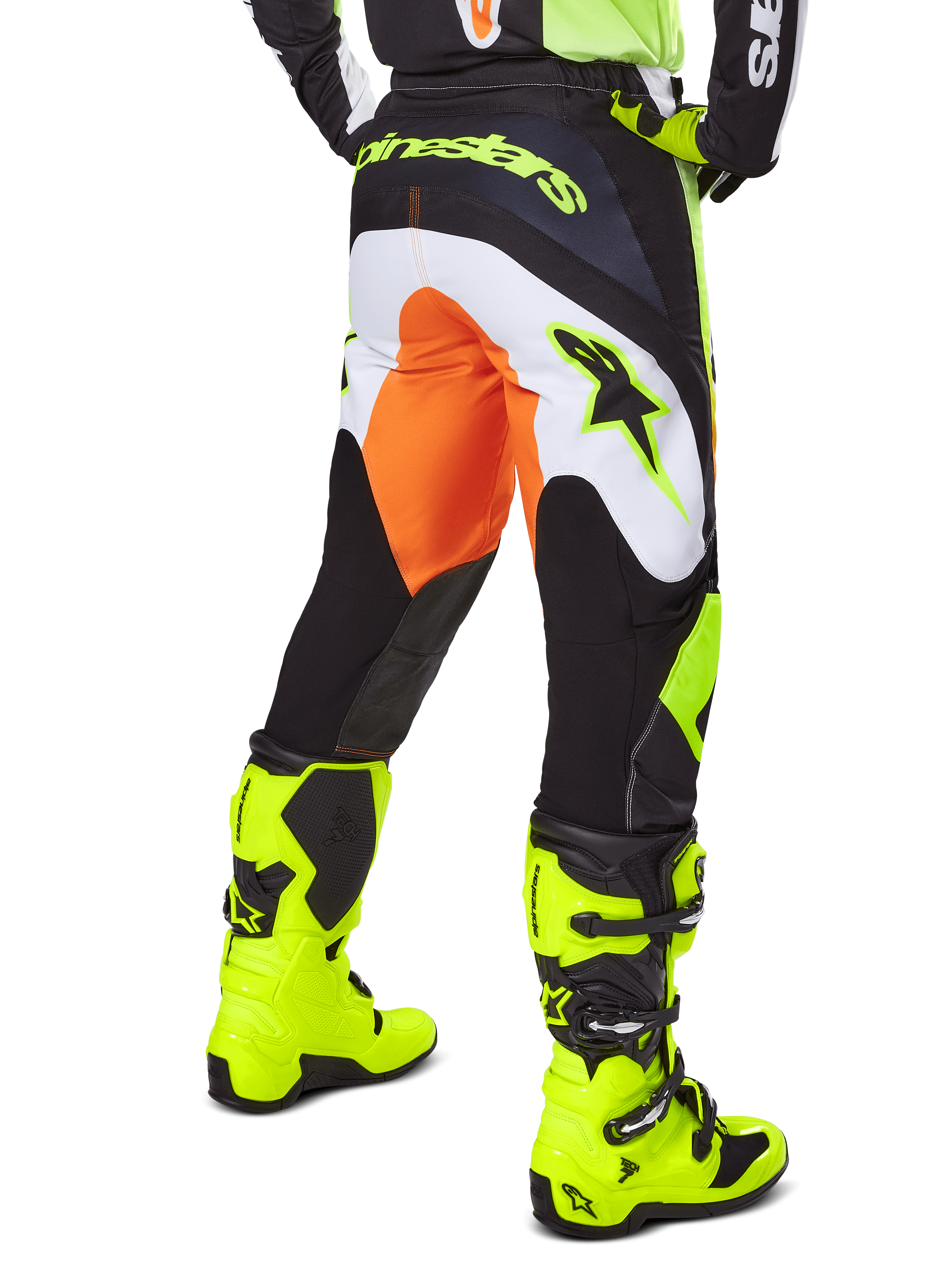 Alpinestars 2025 Fluid Wurx Pants, pantalon de motocross, jaune et noir avec des accents orange et blancs, vue de dos porté avec des bottes jaune vif assorties, construction durable avec logos audacieux pour la conduite tout-terrain