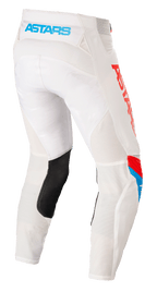 Pantalon Alpinestars Techstar Quadro, pantalon de motocross, blanc cassé avec accents bleu néon et rouge vif, vue arrière montrant le logo 'ASTARS' bleu clair sur la ceinture, panneaux de ventilation en mesh, empiècement en cuir noir à l'intérieur de la jambe et marquage rouge vif sur le côté