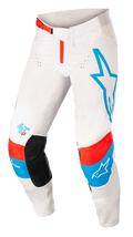 Alpinestars Techstar Quadro, pantalon de motocross, blanc cassé avec accents bleus et rouge néon, grand logo étoile bleue sur la jambe gauche, logo AST 63 sur la jambe droite, empiècements noirs à l'intérieur des genoux, boucle de taille rouge et zones de ventilation perforées pour la performance tout-terrain