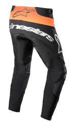 Pantalon Alpinestars Techstar Sein 2023, pantalon de motocross, noir et orange vif, vue arrière montrant l'empiècement orange vif à la taille avec logo noir, large marquage Alpinestars blanc sur l'assise, construction en textile renforcé pour la course tout-terrain