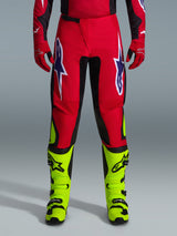 Alpinestars 2026 Fluid Grid Pants, Motocross Pants, Red with black panels and neon yellow accents, featuring large white and purple star logos on thighs, worn with red gloves and neon yellow boots, durable construction for off-road racing