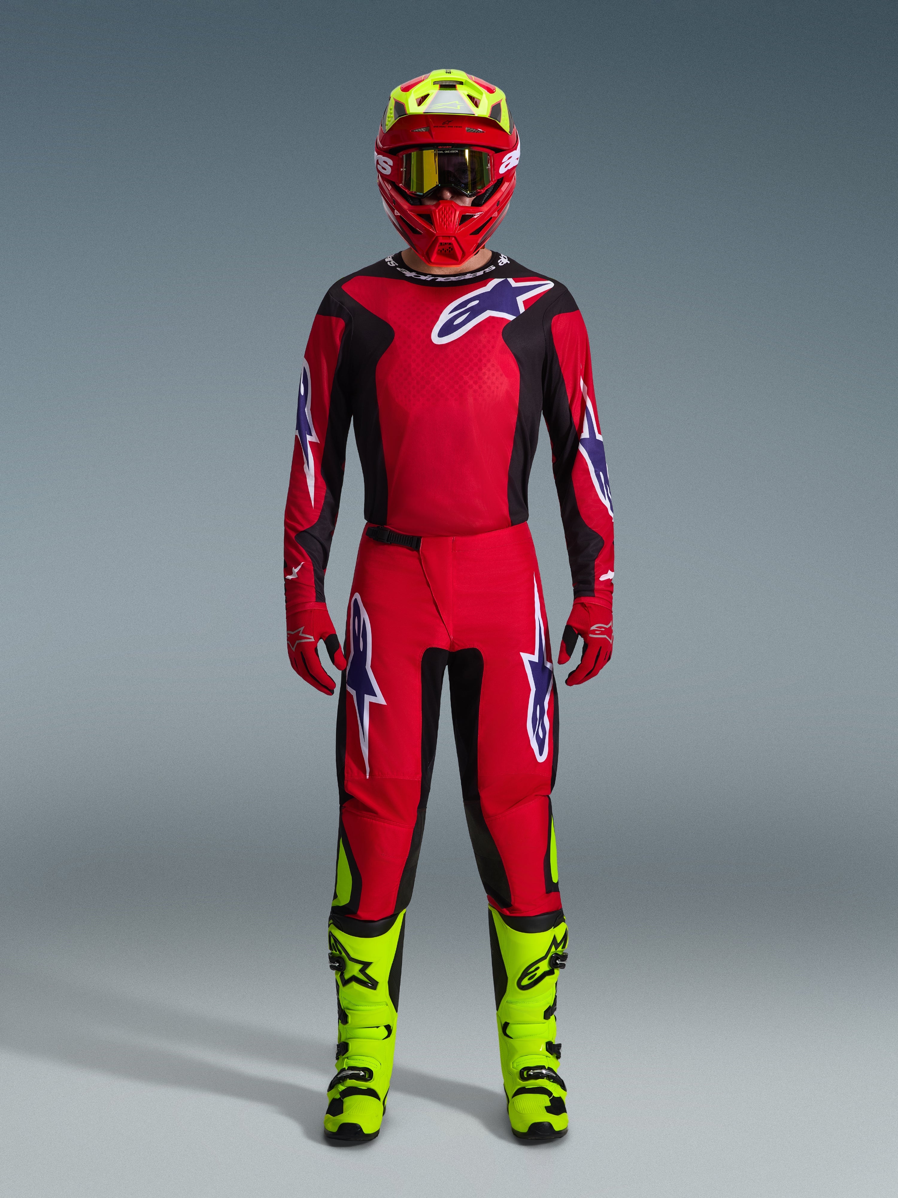 Alpinestars 2026 Fluid Grid Gear Set, tenue de motocross, rouge et noir, équipement de pilotage complet avec maillot et pantalon rouges arborant des logos bleus et blancs, casque rouge assorti avec des accents jaune fluo et bottes jaune fluo, conception haute performance pour la course tout-terrain