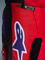 Alpinestars 2026 Fluid Grid Pants, Motocross Pants, Red Black and Purple, close-up of the waist and hip area featuring a black ratchet closure system and a large purple Alpinestars star logo with white outline, durable textured fabric for off-road racing.