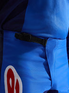 Alpinestars 2026 Fluid Grid Pants, pantalon de motocross, bleu et rouge, vue rapprochée du système de fermeture à cliquet noir à la taille, poly-tissu bleu durable avec accents de logo rouges et blancs, conçu pour la performance tout-terrain