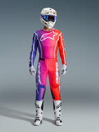 Motocross rider wearing 2026 Fluid Apex Pants and matching jersey, purple and orange gradient, white helmet with goggles, white boots and gloves, coordinated Alpinestars racing gear for off-road performance.