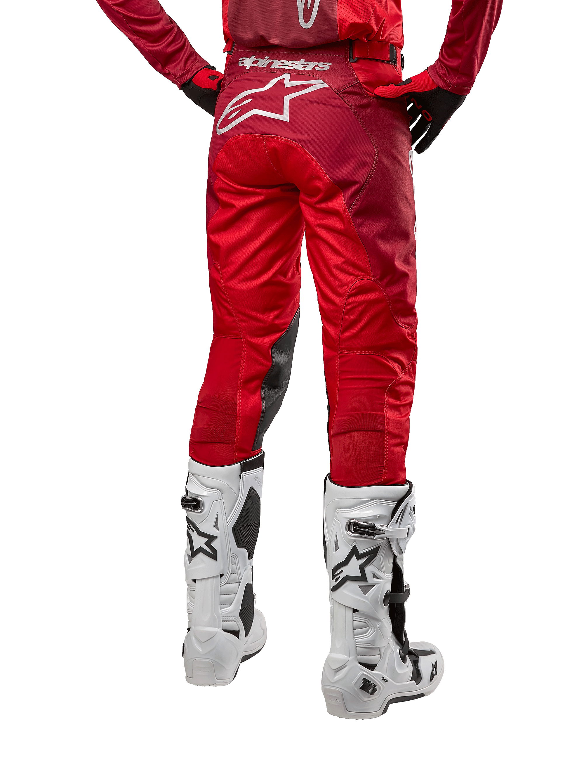 Alpinestars 2024 Racer Hoen Pants, pantalon de motocross, Mars Red Burgundy, vue arrière montrant un grand logo Astar blanc à l'arrière, panneaux intérieurs aux genoux noirs, porté avec des bottes de motocross blanches, équipement tout-terrain haute performance