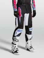 Pantalon Fluid Drag Alpinestars, pantalon motocross homme, noir et blanc avec accents rouge fluo et bleu clair.