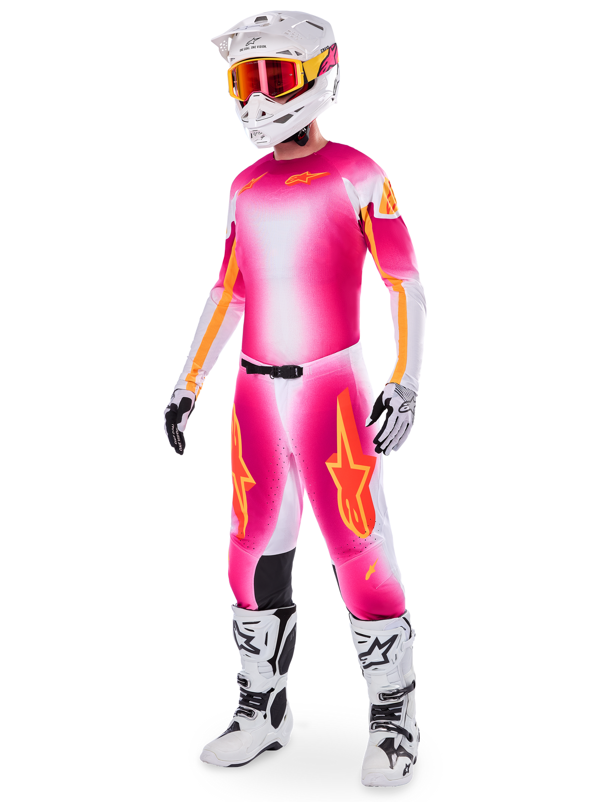 Pilote de motocross portant la tenue Alpinestars Supertech AFD MIG Édition Limitée, maillot et pantalon avec dégradé rose fluo, blanc et orange, casque blanc avec lunettes orange, bottes blanches et noires, tenue de pilotage tout-terrain professionnelle