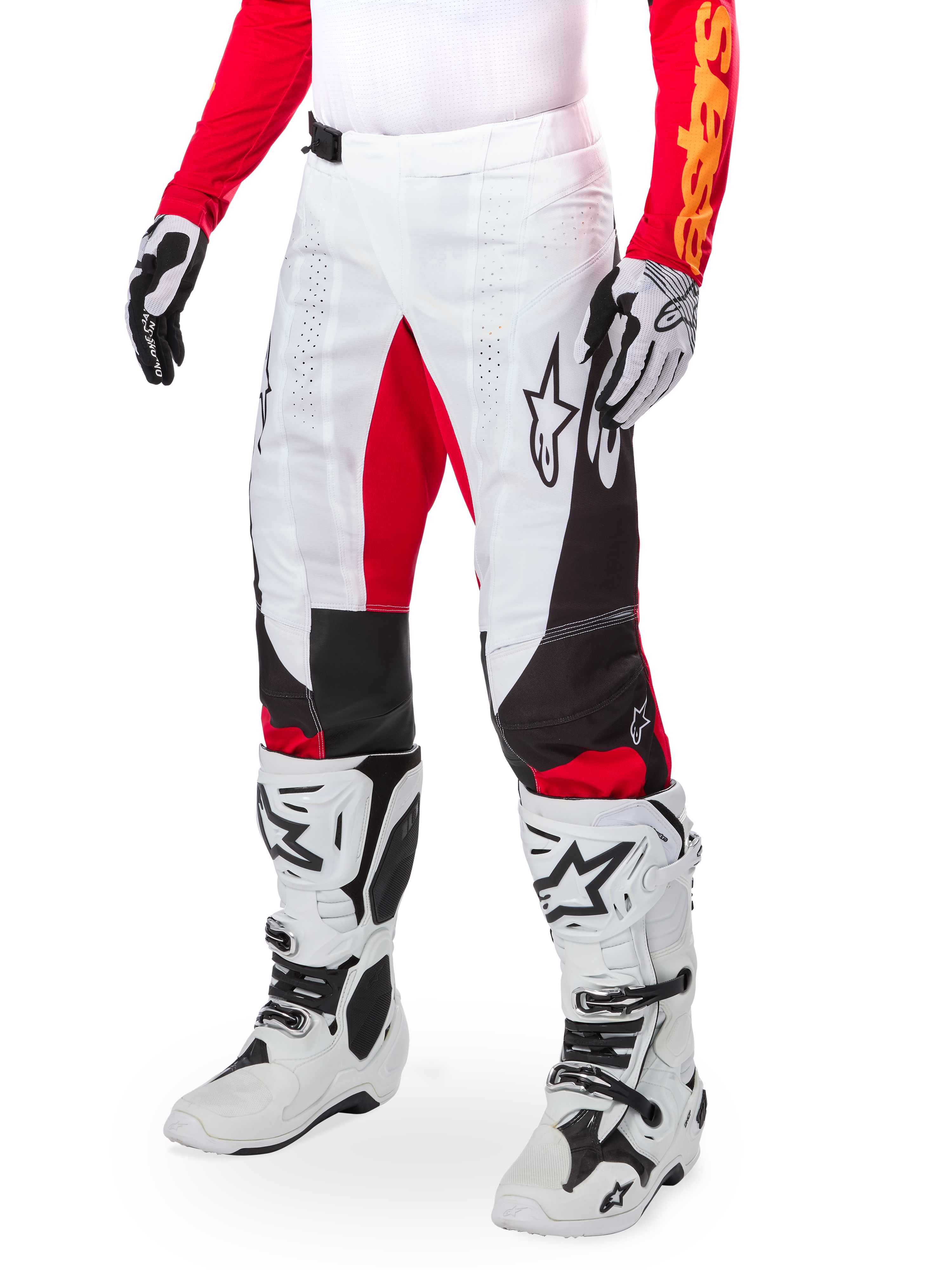 Alpinestars Techstar Deep Édition Limitée, pantalon de motocross, blanc, noir et rouge vif, porté avec des bottes et des gants blancs et noirs, doté de panneaux avant blancs avec des accents rouges et de détails latéraux noirs, conçu pour la course tout-terrain haute performance