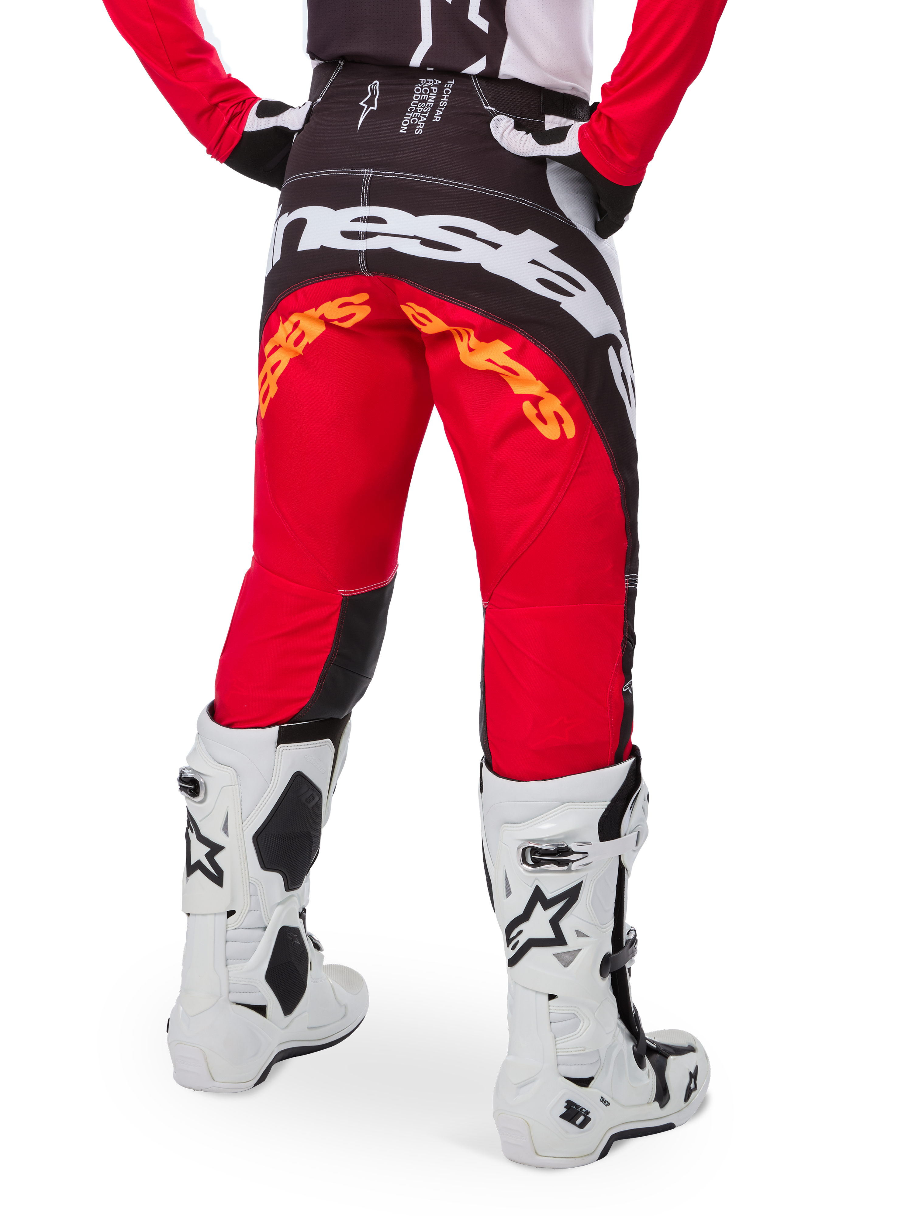 Alpinestars Techstar Deep Édition Limitée, pantalon de motocross, noir, blanc et rouge vif, vue arrière avec logo Alpinestars blanc imposant sur l'assise et marquage orange, porté avec des bottes techniques blanches pour la compétition tout-terrain professionnelle