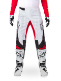 Alpinestars Limited Edition Techstar Deep Pants, pantalon de motocross, noir, blanc et rouge vif, porté avec un maillot rouge assorti, des gants et des bottes blancs et noirs, comprenant des panneaux avant blancs, des accents rouges à l'intérieur des jambes, des panneaux latéraux noirs, des logos Alpinestars sur les cuisses et des détails perforés au laser pour la ventilation.