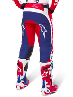 Alpinestars Techstar Fortitude Pants Édition Limitée, pantalon de motocross, rouge, blanc et bleu, vue arrière porté avec des bottes rouges et blanches assorties, arborant des logos d'étoiles blanches sur les cuisses, conception multi-panneaux durable pour la course tout-terrain professionnelle