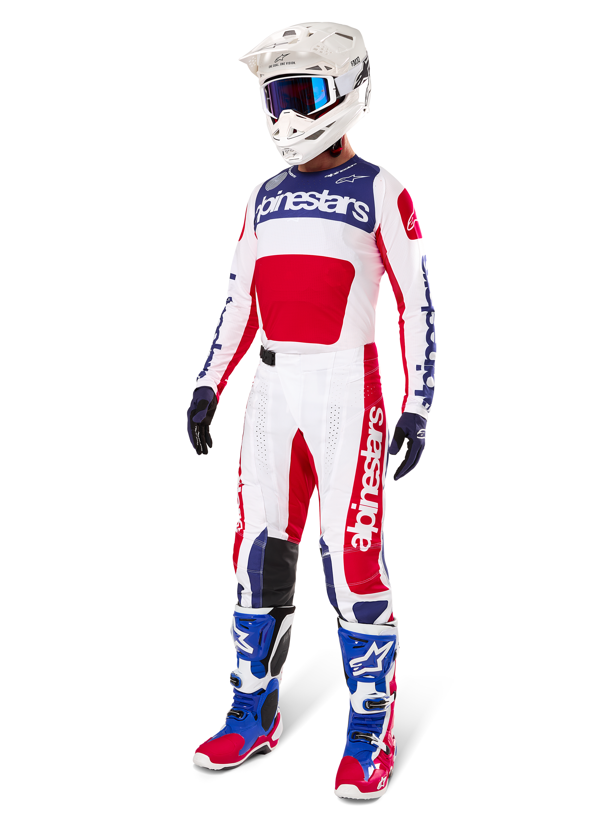 Alpinestars Pantalon Techstar Fortitude Édition Limitée, tenue de motocross, rouge, blanc et bleu, porté avec maillot assorti, casque blanc, lunettes bleues et bottes bleues et rouges, équipement de course professionnel pour compétition tout-terrain