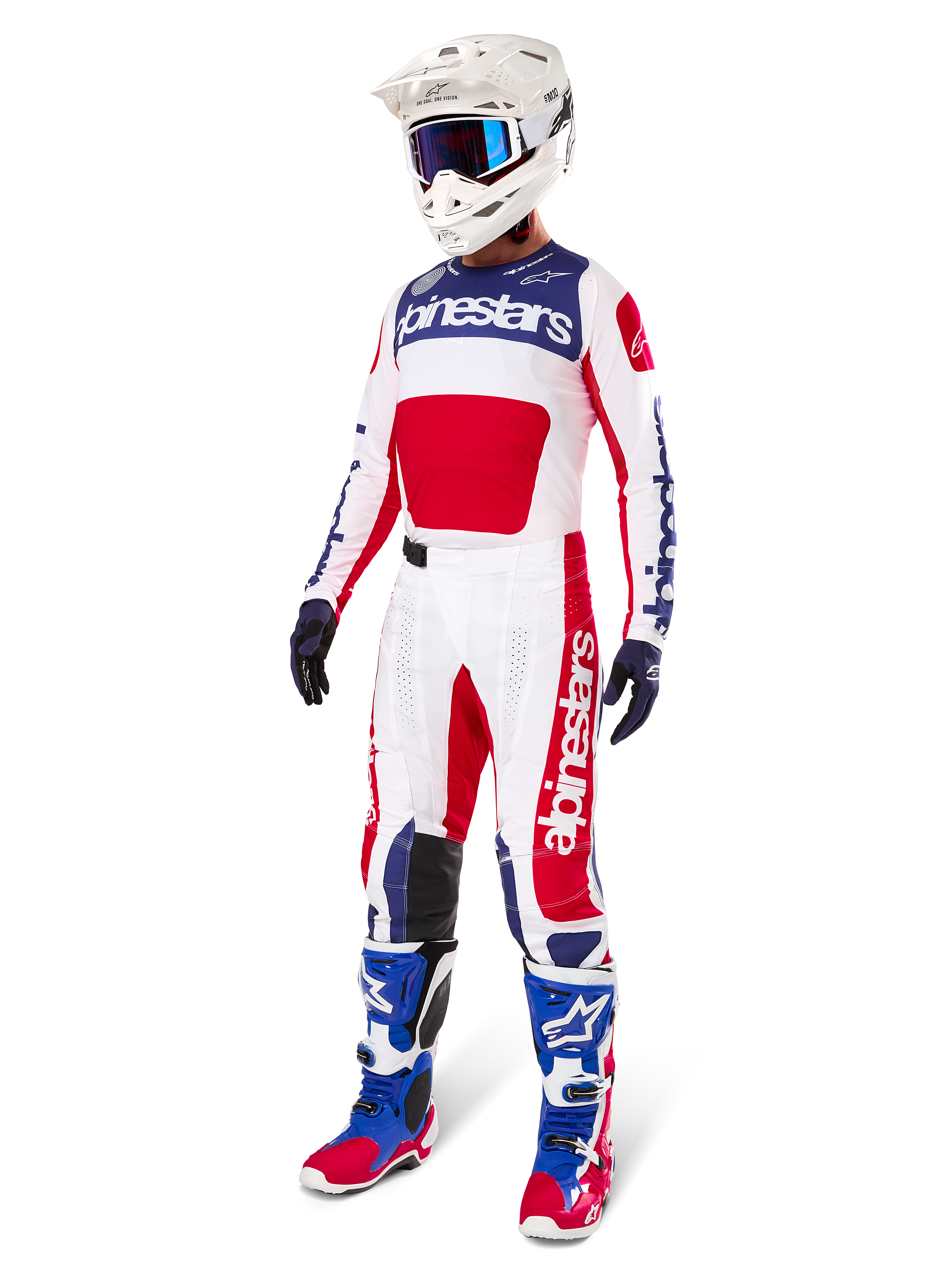 Alpinestars Pantalon Techstar Fortitude Édition Limitée, tenue de motocross, rouge, blanc et bleu, porté avec maillot assorti, casque blanc, lunettes bleues et bottes bleues et rouges, équipement de course professionnel pour compétition tout-terrain