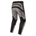 Pantalon Alpinestars Fluid Lurv 2024, pantalon de motocross, Mud Black, vue arrière montrant le marquage Alpinestars imposant à l'arrière et le logo étoilé sur la cuisse droite, design à empiècements gris et noirs en poly-tissu 600D durable pour la conduite tout-terrain.
