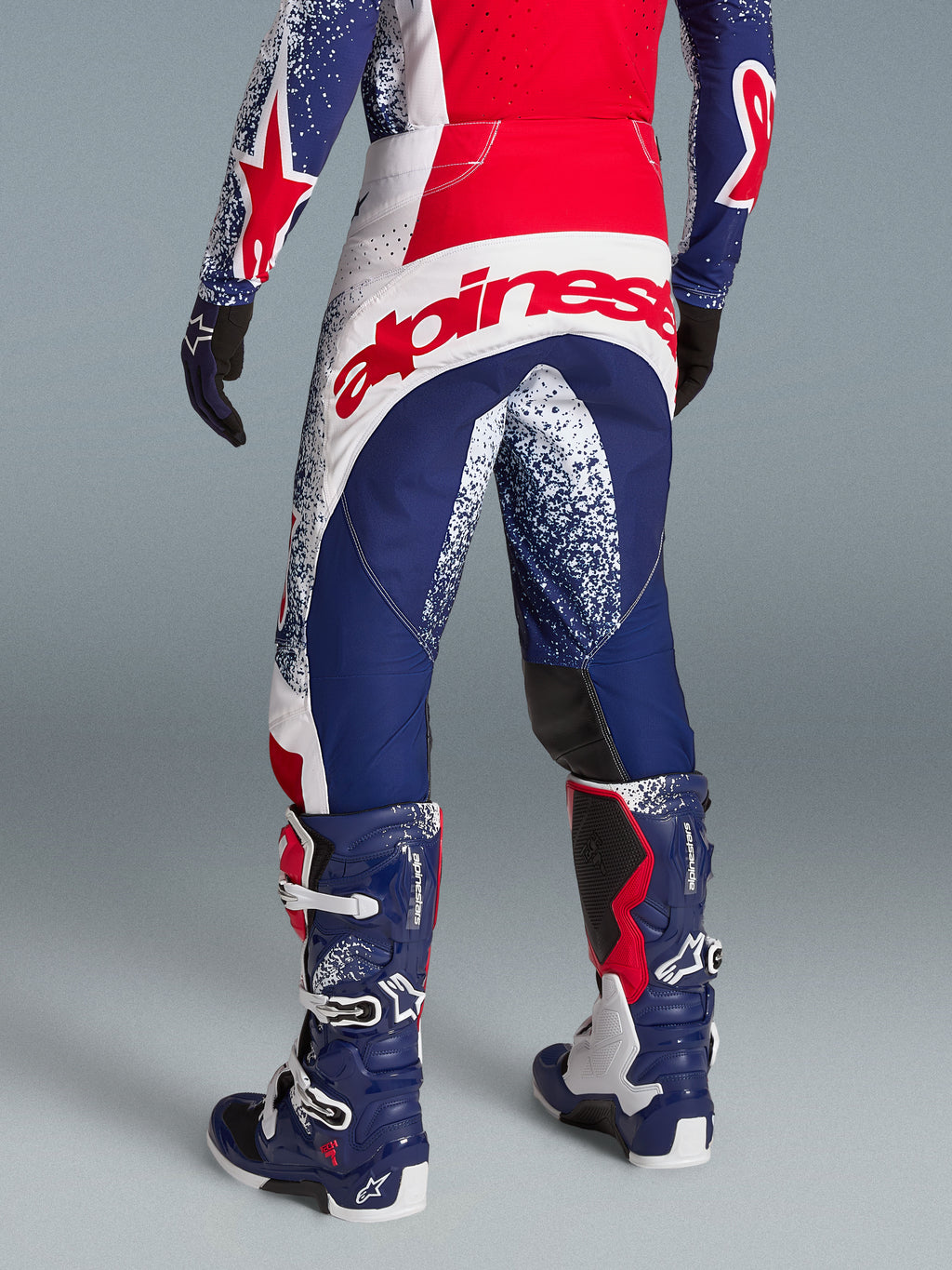 Alpinestars Techstar Unity Pantalons édition limitée, pantalon motocross rouge, blanc et bleu, grand logo arrière, de dos.