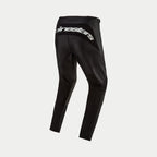 Alpinestars 2024 Fluid Graphite Pants, pantalon de motocross, noir et argenté, vue arrière présentant le logo Alpinestars argenté sur l'empiècement arrière, design sportif avec panneaux renforcés, poly-tissu durable pour la course tout-terrain