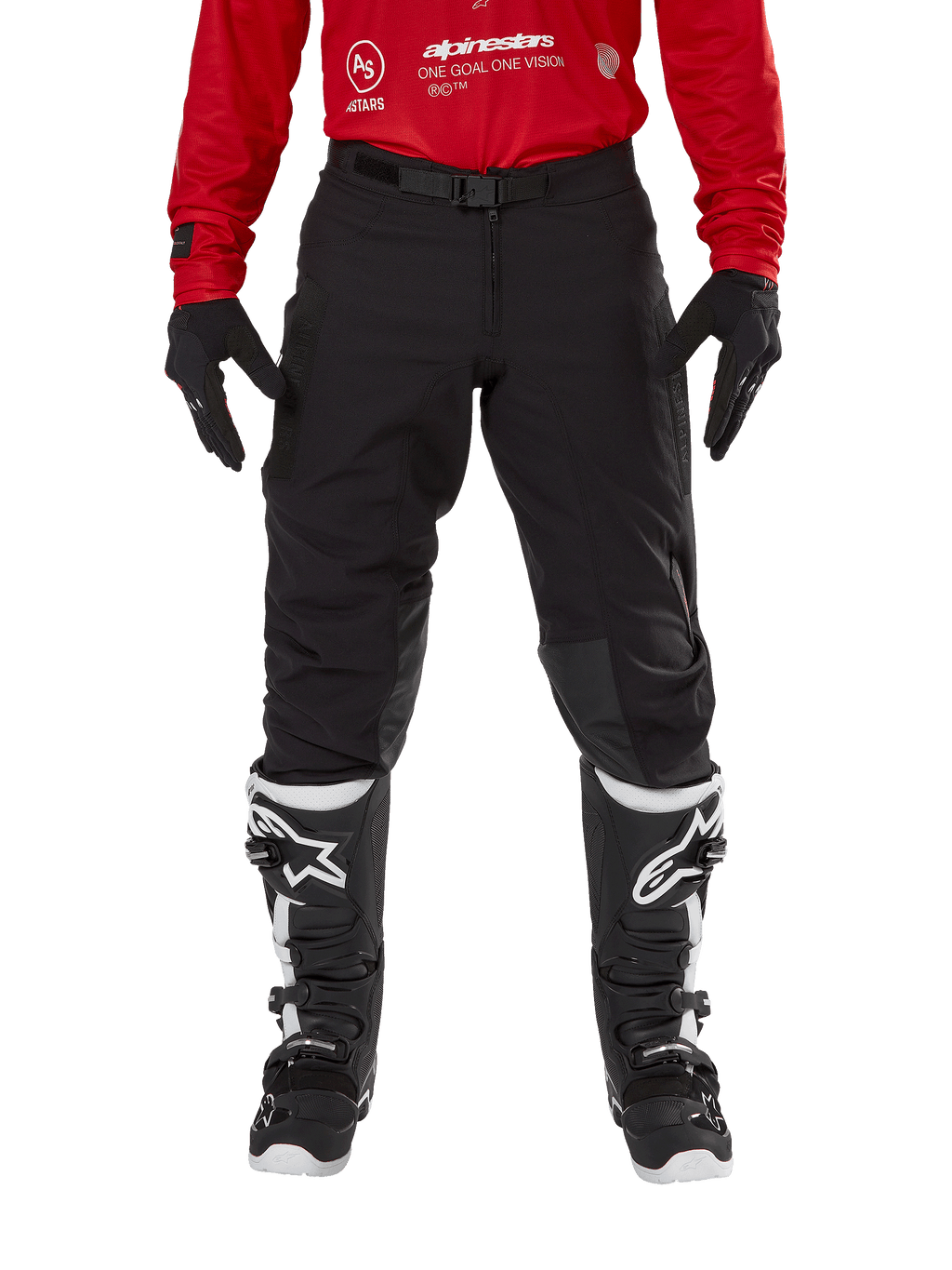 Pantalon Alpinestars Techdura, pantalon d'enduro et de tout-terrain, noir, porté avec un maillot Alpinestars rouge et des bottes noires et blanches, doté d'une construction en toile extensible robuste, d'une boucle de ceinture magnétique réglable et de renforts de genoux en cuir pour la performance tout-terrain