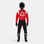Pantalon Alpinestars Techdura, pantalon d'enduro et de tout-terrain, noir, porté avec un maillot Astars à manches longues rouge et blanc, un casque noir et des bottes noires et blanches, doté d'une construction en polyamide extensible robuste et d'empiècements techniques pour la conduite tout-terrain