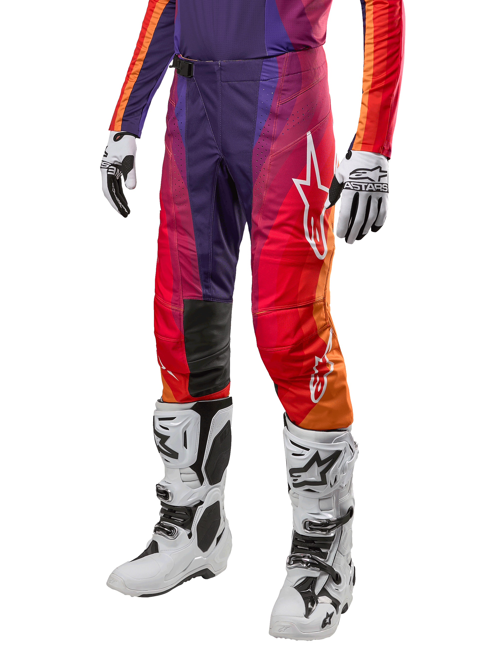 Alpinestars 2024 Techstar Pneuma Pants, pantalon de motocross, dégradé de violet, orange et bleu avec logo Alpinestars blanc, porté avec des gants et bottes de moto blanches, équipement technique pour le tout-terrain