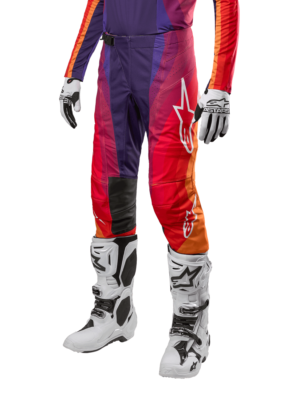 Alpinestars 2024 Techstar Pneuma Pants, pantalon de motocross, dégradé de violet, orange et bleu avec logo Alpinestars blanc, porté avec des gants et bottes de moto blanches, équipement technique pour le tout-terrain