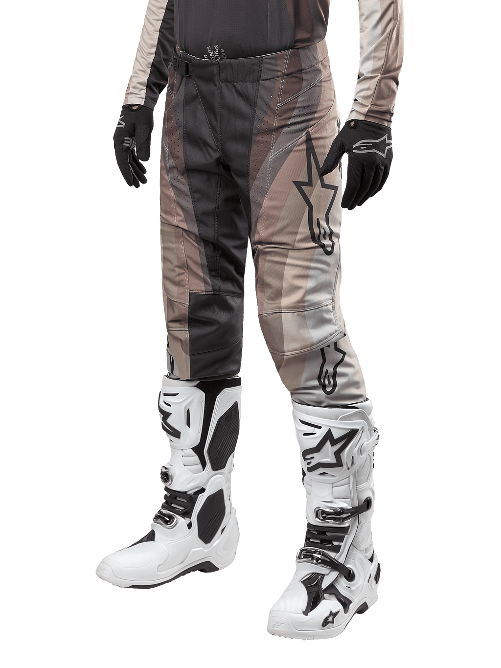 Pantalon Alpinestars Techstar Pneuma 2024, pantalon de motocross, sable foncé et gris poussière de fer, porté avec des bottes blanches et noires et des gants noirs, avec un motif ondulé et un grand logo étoile, équipement durable pour la course tout-terrain